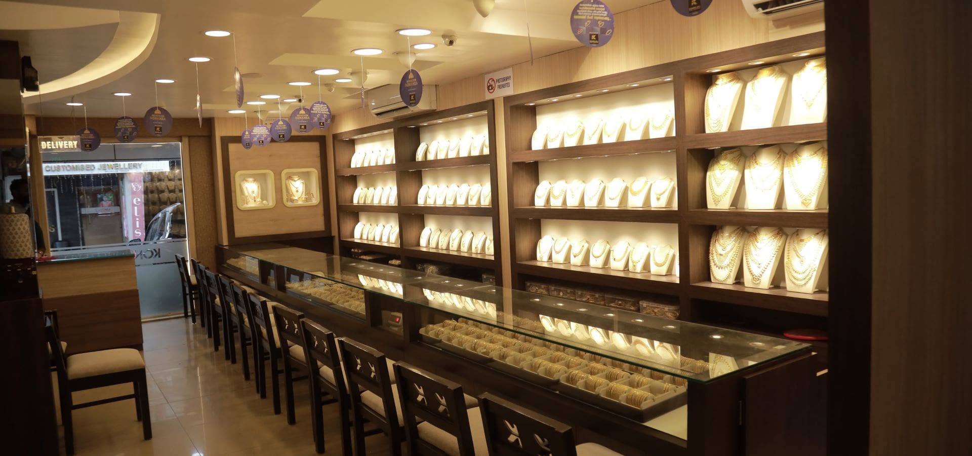 Inside Theyyampattil Jewellery showroom — illuminated gold display counters, Tirur
